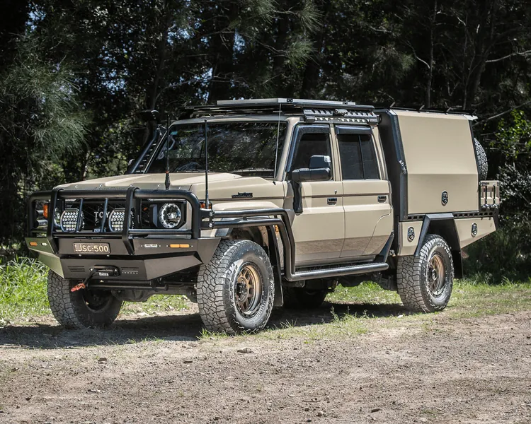 Beige Toyota LandCruiser 79 Series with custom canopy, roof rack, bull bar, and premium off-road setup